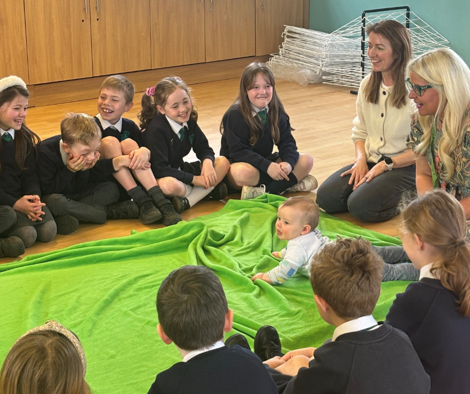 Photograph of primary 5 pupils with teacher and Roots of Empathy Mother/Baby during a lesson