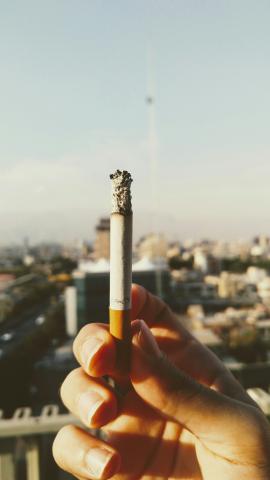 close up of a hand holding burning cigarette