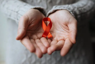 hand holding red ribbon world aids day