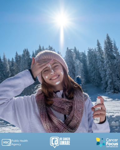 Photograph of woman putting suncream on her face on a winter skiing holiday.