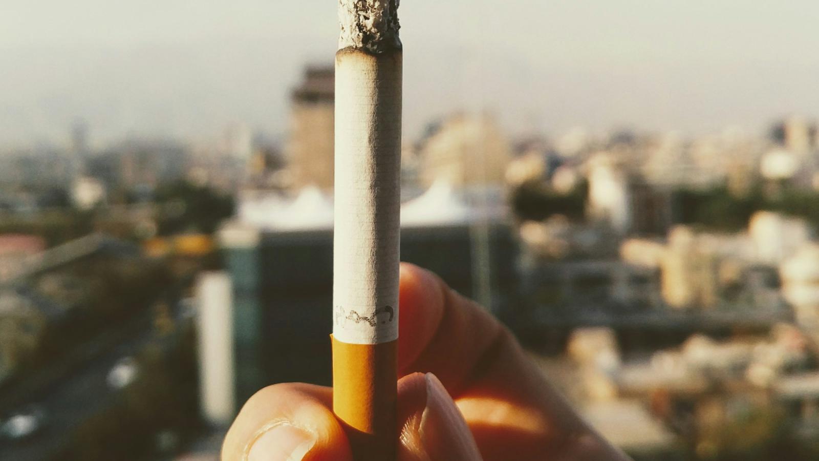 close up of a hand holding burning cigarette
