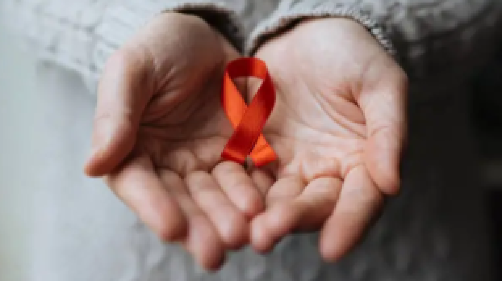 hand holding red ribbon world aids day