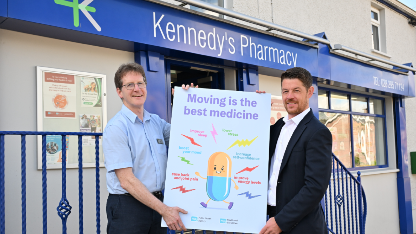 living well campaign launch with two men in front of the pharmacy promoting a signage