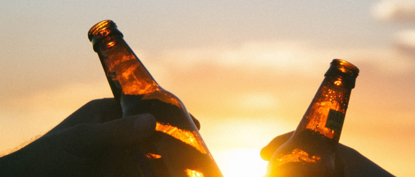 two bottles of beer against the sunset backdrop