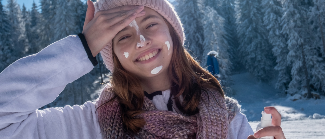 care in the sun awareness (girl applying sunscreen, winter landscape)